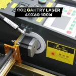 Close-up of the stepper motor and gantry rail system inside a 100W CO2 laser engraver.