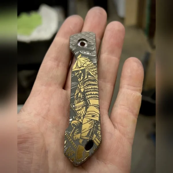 Titanium knife scale engraved with a samurai design using a 60W JPT EM7 fiber laser