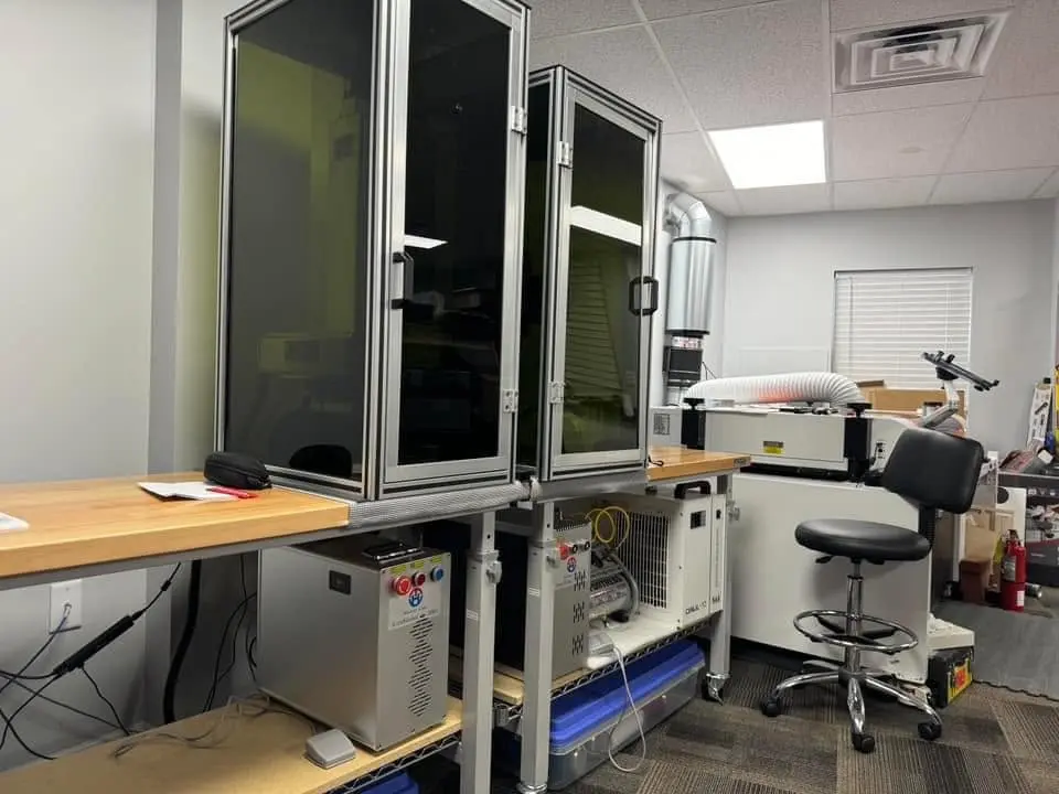 Two Haotian fiber lasers in safety enclosures at a customer office