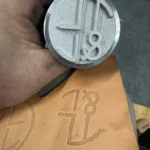 Aluminium leather branding iron deep engraved with 100W JPT M7 MOPA fiber laser, with the stamped logo on veg tan leather